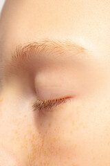 Eyelid, eye closed. Close up portrait of beautiful redhair caucasian female model. Parts of face....