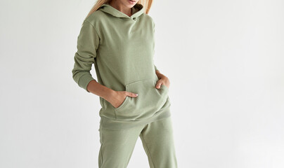 girl wears light green hoodie and pants. studio shot for sport clothing sale