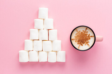 Marshmallow pyramid or Christmas tree and mug of coffee with cinnamon snowflake on pink background