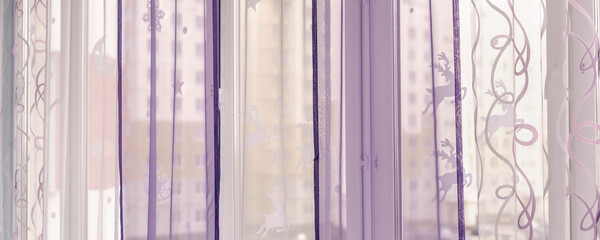 Large white and purple curtain hangs on home window