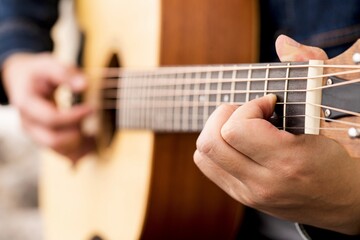 musician playing strum acoustic guitar.