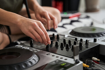 Hands of female Dj playing music