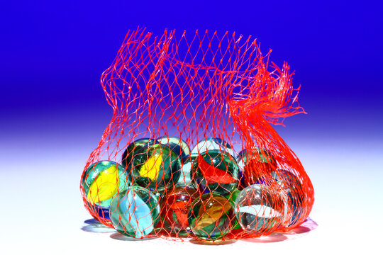 Colourful glass marbles in a plastic net bag