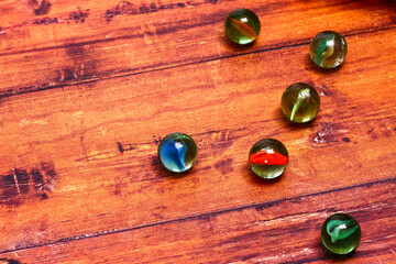 Colourful glass marbles with space for copy on a wooden background