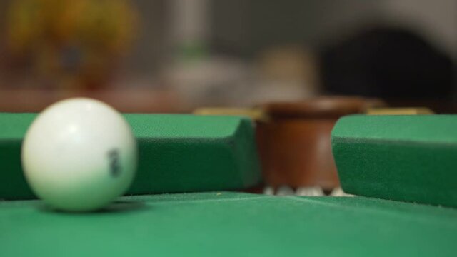 White billiard ball kicking in other ball and falling in net pot close view