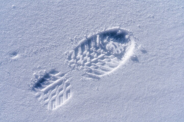 fresh footprint of a mountain boot in hard frozen snow