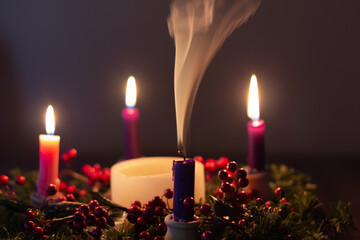 Obraz na płótnie Canvas Advent wreath in dark room, one candle with smoke