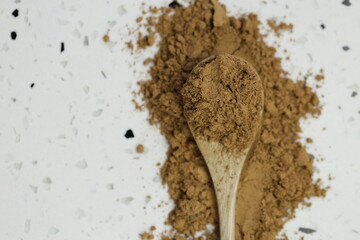 Guarana powder in wooden spoon on white marble background.Super food. Useful product. Healthy eating. Natural energetic. Portion of Guarana Powder. top view, copy space.