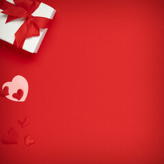 Gift with hearts on red background with place for text. Valentine day concept