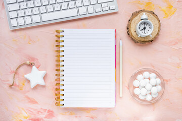 Notepad, pen, computer keyboard, clock, chocolate on woman desk workspace, pink background. Winter holidays preparation, goals, lifestyle concept. To Do List template. Flat lay, top view, mock up