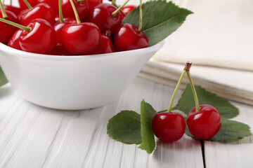 Some ripe cherries near bowl with cherries on white wooden table, small depth of focus.