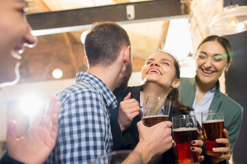 Laughting. Happy co-workers celebrating corporate event after tensioned work day. Look delighted, friendly, cheerful. Drinking beer. Concept of office culture, teamwork, friendship, holidays, weekend.