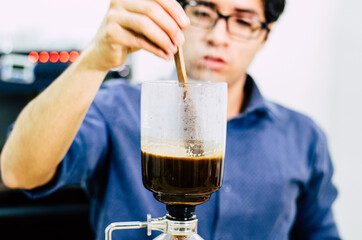 Professional coffee maker - Barista using coffee siphon brewing hot espresso at coffee shop