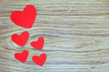 Red hearts on a wooden background. Paper hearts.