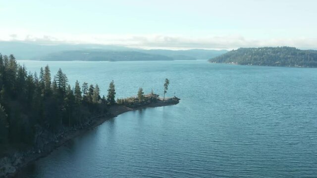 Panning around Tubbs Hill tree on Coeur d'Alene lake in scenic aerial shot