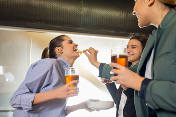 Snack. Happy co-workers celebrating corporate event after tensioned work day. Look delighted, friendly, cheerful. Drinking beer. Concept of office culture, teamwork, friendship, holidays, weekend.