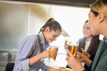 Talks. Happy co-workers celebrating corporate event after tensioned work day. Look delighted, friendly, cheerful. Drinking beer. Concept of office culture, teamwork, friendship, holidays, weekend.