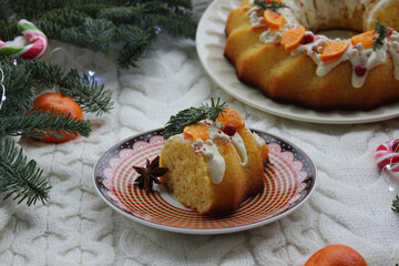 On the plate is a new year's dessert decorated with coniferous branches and tangerines