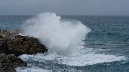 waves crashing against the rocks on a windy day