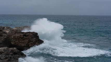 waves crashing against the rocks on a windy day