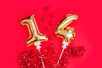 Golden 14 balloons, souvenir heart isolated on red background. Helium balloons, gold foil numbers. Numbers for Valentine's day. Party decoration, celebration, carnival.