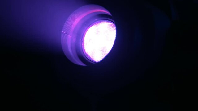 Purple soffit light and dust at gig. Concert light illumination. Party at the club. Shining rays rotating and making flare. Disco at night club. Celebration and perfomance.