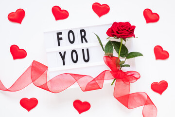 Valentine's day, love, romantic concept. Fresh red rose flower with ribbon and text for you on lightbox on white background. Greeting card. Flat lay, top view