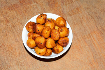 Sugar palm fritters or taler bora in a white bowl on wooden back