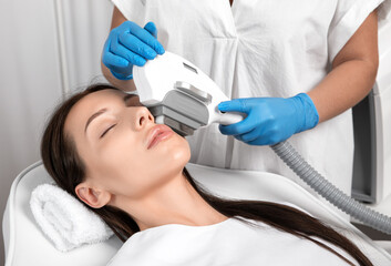 Elos epilation hair removal procedure on the face of a woman. Beautician doing laser rejuvenation...