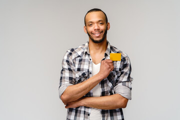 Young african-american man smiling and showing credit card with empty copy space