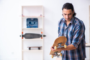 Young man repairing skateboard at workshop