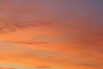 Sun below the horizon and clouds in the fiery dramatic orange sky at sunset or dawn backlit by the sun. Place for text and design