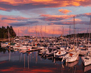 Summer sunset and colorful sky over marina with many boats
