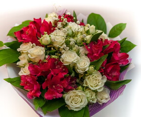 Bouquet of red Alstroemeria and white Roses close up on a white background