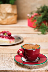 Cup of espresso on a wooden rustic table. Cherry pie in the background. Minimalistic style. Close-up, selective focus