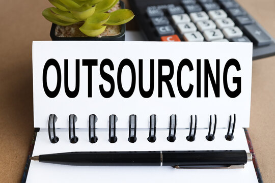 outsorcing, text on white paper on calculator background