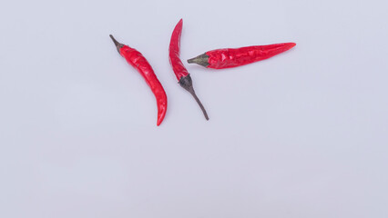 Close-up view of red hot chili peppers on white background. Spicy cuisine concept.