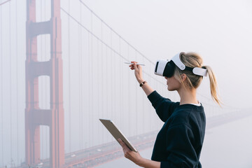 Unrecognizable woman in VR goggles using digital pencil