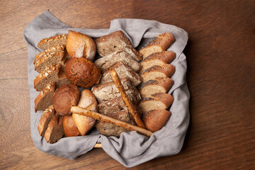 Basket with fresh bread on wooden table background