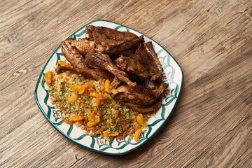 Roasted turkey and couscous on wooden table background