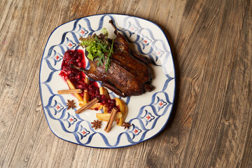 Roasted duck with quince on wooden table background