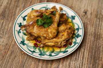 Fried chicken legs with pomegranate and parsley on wood table