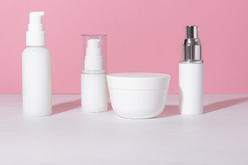 Set of white cosmetic bottles and jars with hard shadows. Beauty salon concept.