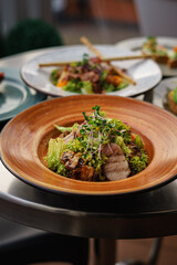 Several vegetable and meat salads on the table