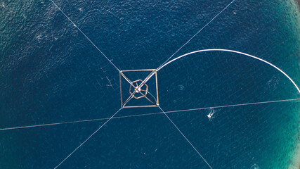 Salmon fish farming in Norway sea. Food industry, traditional craft production, environmental conservation. Aerial view of round mesh for growing and catching fish in arctic water