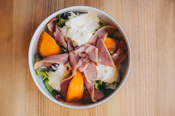 Salad with persimmon and stracciatella cheese on the table
