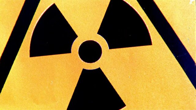 Grainy cross-processed 16mm film footage of a radiation warning sign