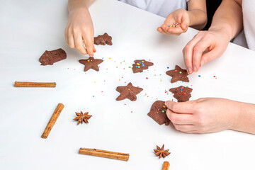 Cooking Christmas and  New Year chocolate cookies or gingerbread. Traditional festive baking, bake with kids. Step 13 decorate baked gingerbread with multi-colored sweet sprinkles. Step by step recipe
