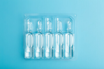 Medical ampoules with a vaccine on a blue background. Medicine for disease or medicine for health...