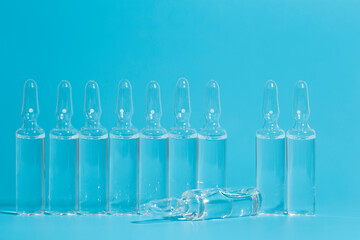 Medical ampoules with a vaccine on a blue background. Medicine for disease or medicine for health concept.